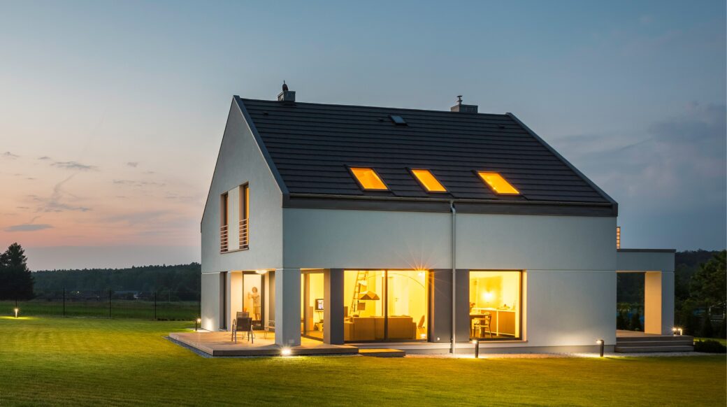 Beleuchtetes Haus mit Photovoltaikanlage und Stromspeicher