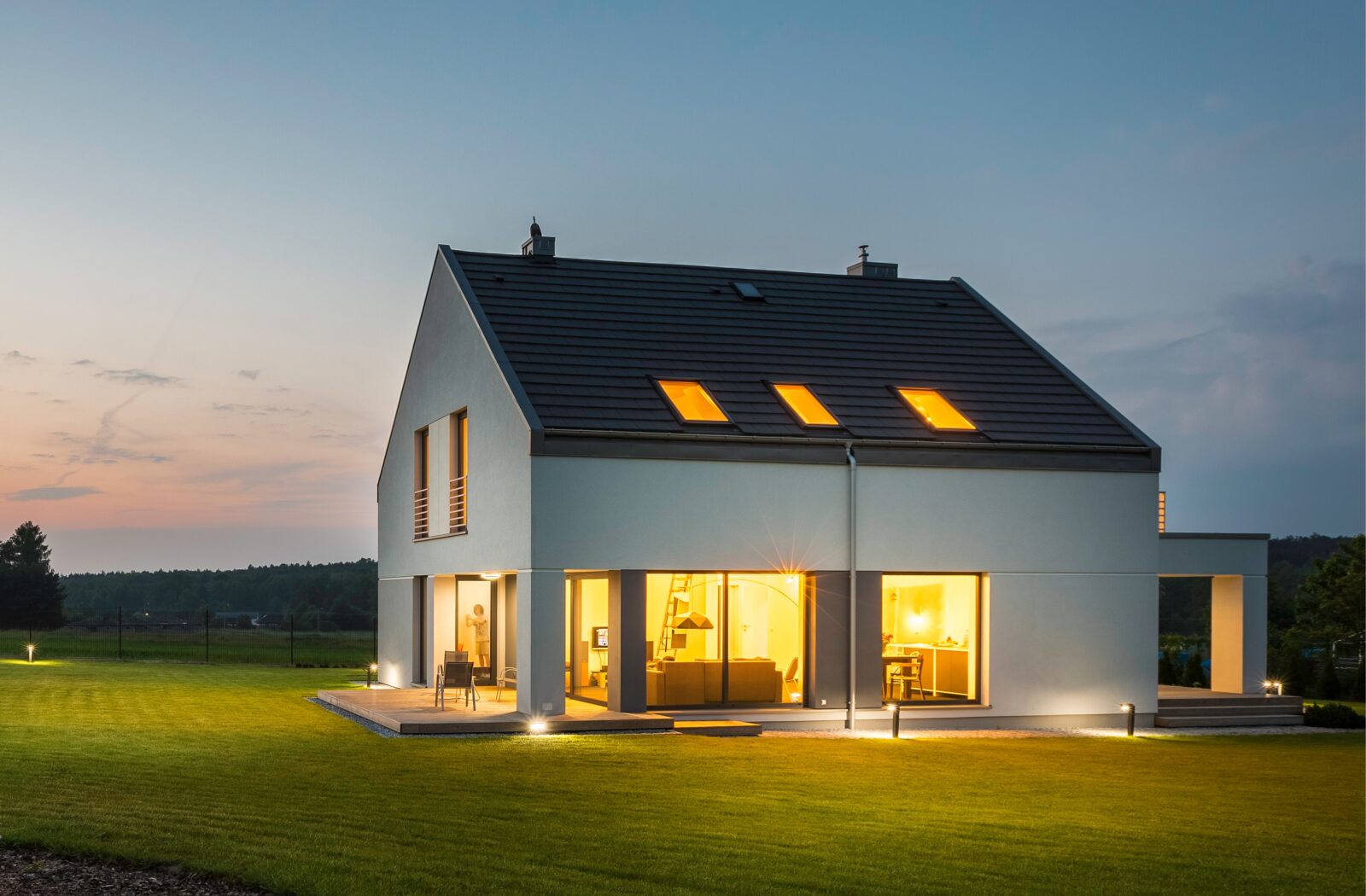 Beleuchtetes Haus mit Photovoltaikanlage und Stromspeicher